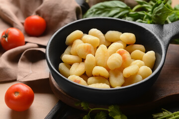 Frying pan with tasty gnocchi on table