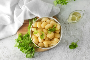 Bowl with tasty gnocchi on light background