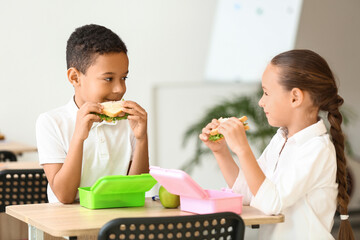 Cute little children having lunch at school
