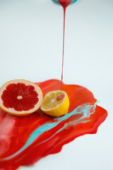 Half of lemon ang grapefruit on the color juice with juicy liquid are flowing down  - 458873876