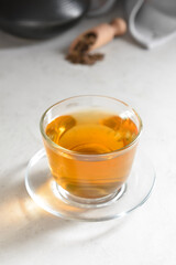 Cup of tasty hojicha green tea on light background