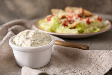 Bowl of tasty Caesar sauce on table, closeup