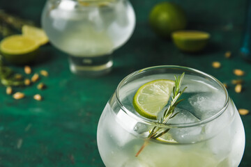 Glasses of cold gin tonic on color background