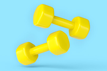 Pair of rubber yellow dumbbells isolated on blue background