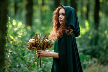 Young witch in green forest