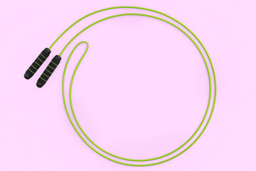 Green skipping rope or jumping rope isolated on pink background.