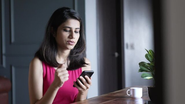 Upset indian Businesswoman looking at smartphone screen feels sad and disappointed with bad news messages on phone. Unhappy and Stressed asian Female Receive bad news in home office.