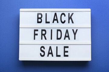 Board with text BLACK FRIDAY SALE on color background