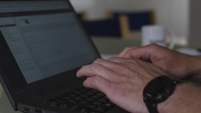 Male sending e-mails on a laptop filmed in slow motion.