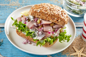 Delicious sandwich with fish on wooden table