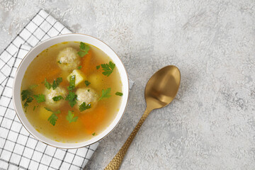 Bowl with tasty meatball soup on light background