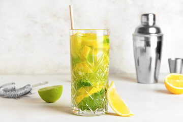 Glass with tasty lemonade on light background