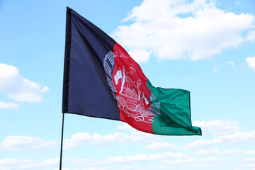 Waving Afghanistan flag against blue sky