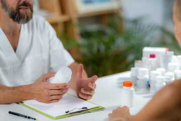 Quantum Medicine. Doctor Holding a Supplement Bottle, recommending supplements to a client.