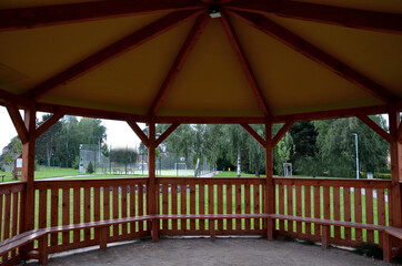 polygonal pergola with benches and a fence around the perimeter. there is a lot of space inside....