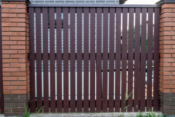 Wooden fence made of planed boards, picket fence. Fencing of a house, structure. Wooden gate....