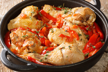 Basque Braised Chicken with Peppers Poulet Basquaise close up in the pan on the table. Horizontal
