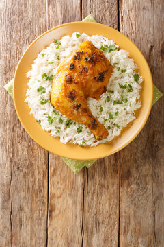 Ayam Percik Coconut Spiced Chicken with rice close up in the plate on the table. Vertical top view from above