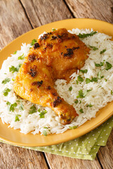 Malaysian Roasted Spiced Chicken Ayam Percik with rice close up in the plate on the table. Vertical
