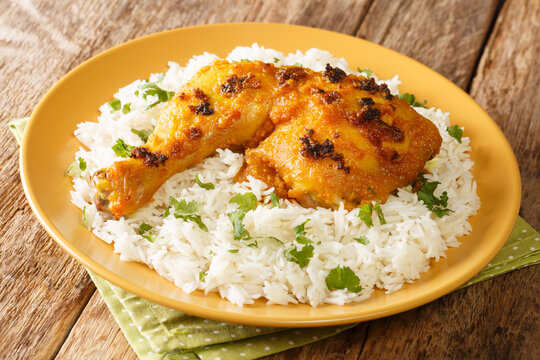 Ayam Percik a Malaysian grilled chicken marinated in flavorful spices served with rice close up in the plate on the table. Horizontal