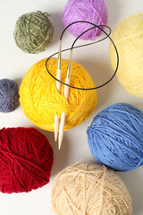 Balls of yarn with knitting needles on white background