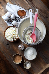 Homemade cheesecake ingredients: cottage cheese, eggs, coconut sugar, salt, corn starch, baking powder and spices on the table