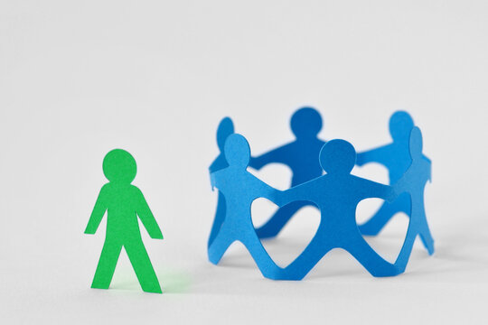 Group of people holding hands in circle and person alone - Concept of social exclusion and isolation