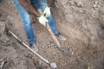 Caucasian worker digging a hole.