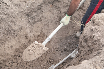 Caucasian worker digging a hole.