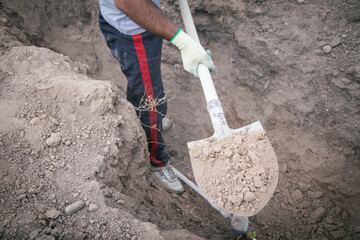 Caucasian worker digging a hole.