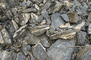 Closeup view of irregular stone pile with uneven shapes monochromatic background texture