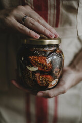 sun-dried plums in a jar in the hands of a girl