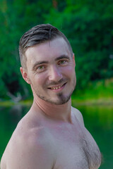 Close-up Portrait of Handsome Man Standing on the Beach After Swimming. Wet Hair, Radiant Smile. Human Beauty Concept. Leisure concept.