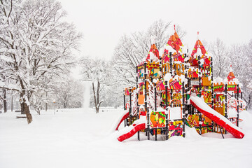 children's playground in the form of a fairytale castle during a snowfall in a winter park