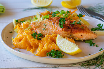 Fried salmon with sweet potatoes and vegetables on a plate