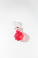 Beautiful glass bottle i bright red drink on a white background. Minimalist composition photographed from above 