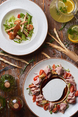 salads with boiled pork and shrimp on a wooden table with sauces