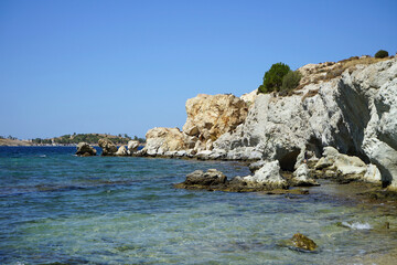 Schroffe Felsen in einer idyllisch gelegenen Bucht am Ägäischen Meer und Mittelmeer vor blauem...