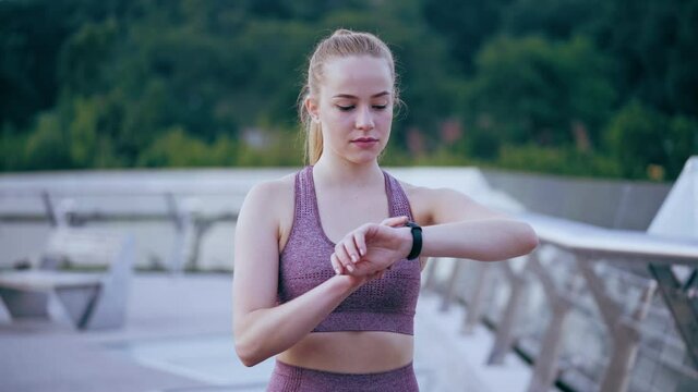 Young athletic woman timing her training and checking pulse and blood pressure