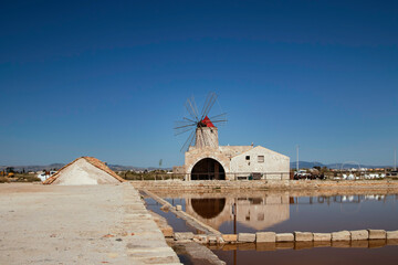 salt pans of Nubia, near Trapani and Marsalla (Sicilia, Italy) with one windmill in the background - obrazy, fototapety, plakaty