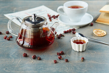 Obraz na płótnie Canvas Hot tea in glass teapot and cup, on table