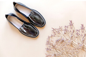 Fashionable minimalistic composition, women's black shoes with dried flowers. The arrival of...