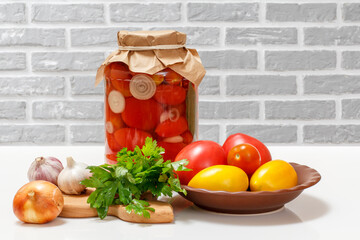 Pickled tomatoes in glass jar on kitchen table.