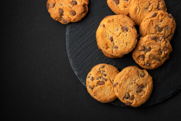 Fresh crispy chocolate cookies on a dark table