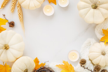 Hello Autumn or Happy Thanksgiving banner frame with phite pumpkins and orange fall leaves on a white marble background with plenty of copyspace for seasonal greetings