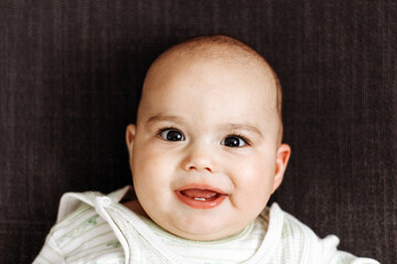 Sweet little baby boy with chubby cheeks and big eyes. Portrait of happy smiling infant