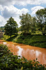 Kuks, East Bohemia, Czech Republic, 10 July 2021: Elbe River after rain with yellow, dark orange...