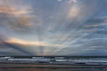 Fototapeta premium Sunbeams at Woodend Beach, south island, New Zealand.