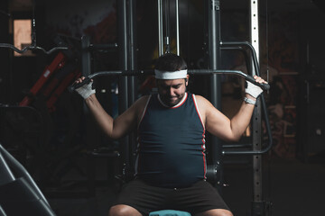 a funny fat boy doing sports inside a gym.
overcoming concept.
willpower.