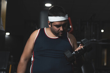 Obraz na płótnie Canvas a funny fat boy doing sports inside a gym. overcoming concept. willpower.